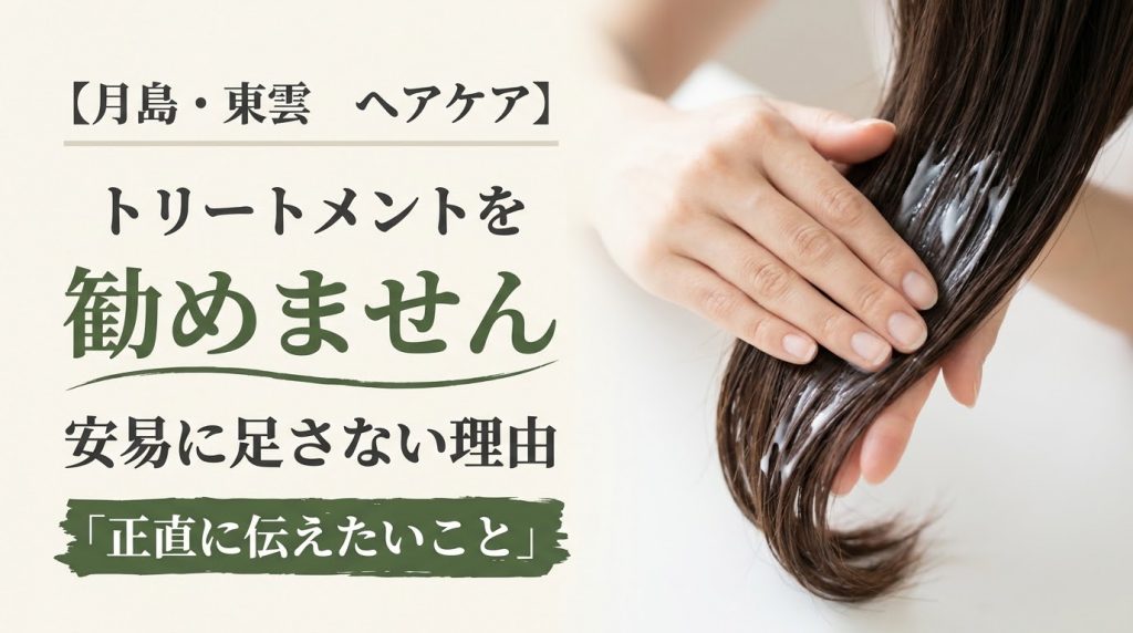 髪にトリートメントをなじませている手元